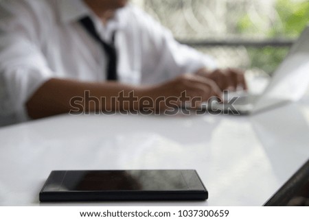 Blur Image of business people who are working out and using a smartphone as an internet connection (Wi-Fi) to his laptop .To monitor the investment and the stock market.