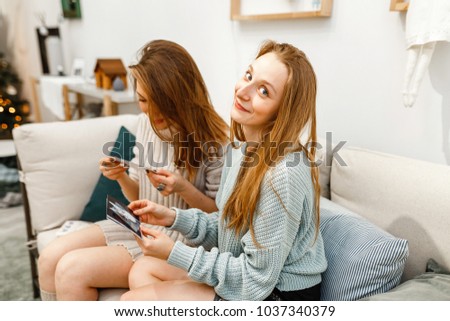 girls friends relaxing and looking at the photo album in their apartment