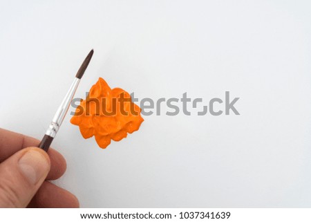 a drop of acrylic orange color on a white surface