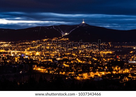 Night view on the city "Liberec". City of lights. The hill "Jested" over the glowing town. Royalty-Free Stock Photo #1037343466