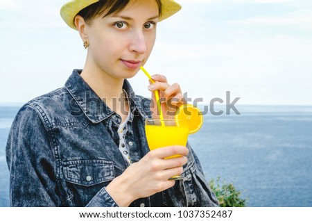 Diet. Healthy eating. Smiling woman holding lemonade drink in glass background sea wild nature outdoor beach cocktail. Fresh detox vegetable orange juice. Healthy lifestyle, vegetarian food. 