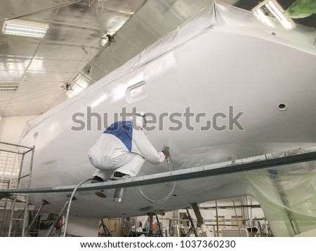 workers repairing and painting the Sailing yacht at shipyard , factory in Phuket,Thailand Royalty-Free Stock Photo #1037360230