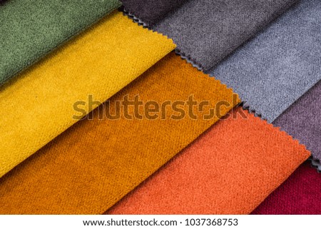 Colorful and bright fabric pattern palette texture samples as abstract textile background. Handmade, clothes and furniture decoration concept. Closeup studio shot with soft selective focus. Toned.