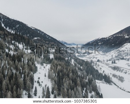 Aerial view of valley in Swiss mountains, snow covered landscape