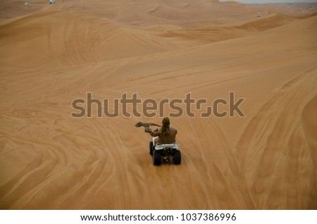 While desert safari in Dubai, falcon keeper offers to take picture with his pet falcon.