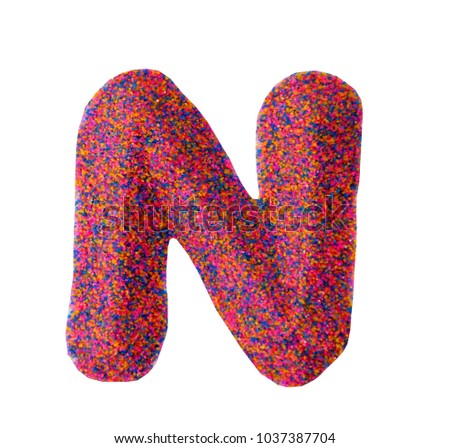 Beautiful Alphabet N, made by multi color sand, isolated on white background
