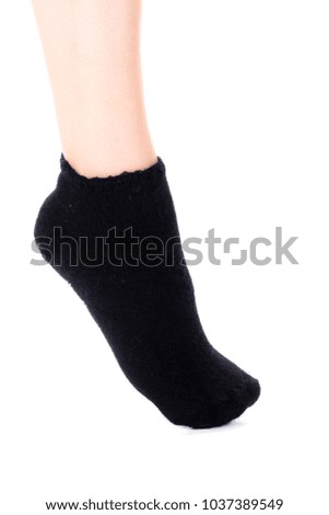 Side view of beautiful human foot dressed in new nice and soft natural cotton fabric blank black sock isolated on a white background. Wearing and sport clothes concept. Detailed closeup studio shot.