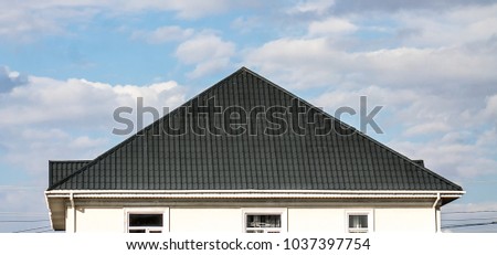 Roof of a house made of metal profile against a blue sky