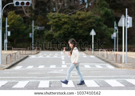 Little girl crossing a pedestrian crossing