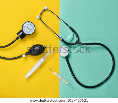 Medical equipment on a colored paper background. Stethoscope, syringe, thermometer, tonometer. Top view, flat lay.
 Royalty-Free Stock Photo #1037423521