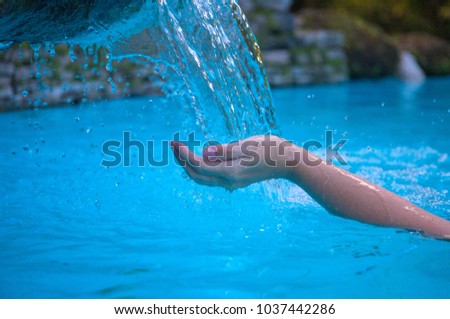 Woman hand and blue water. Cool water stream and hands. Fresh water current. Woman hands in clean flow. Hands hygiene concept photo. Calming moisture from natural water source. Summer refreshment
