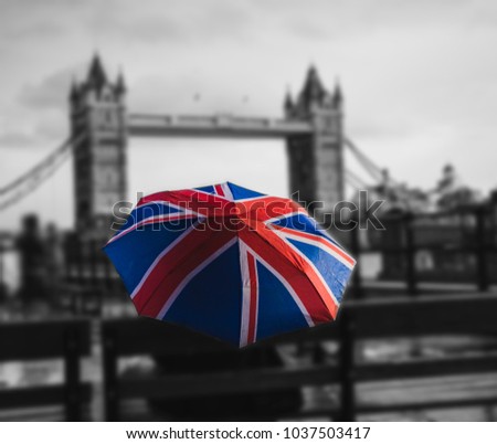 ?olored umbrella in the form of British flag (selective focus), on a black and white background of a bridge in London across the River Thames