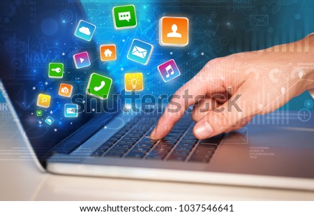 Hand using laptop with bouncing colorful application and global reports and graphs concept
