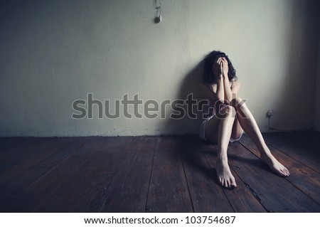 sad woman sitting alone in a empty room Royalty-Free Stock Photo #103754687