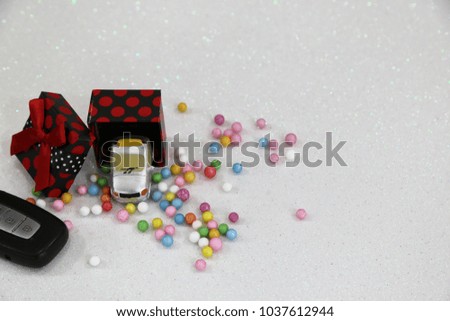 Car with gift package and colorful bubbles on the white background  