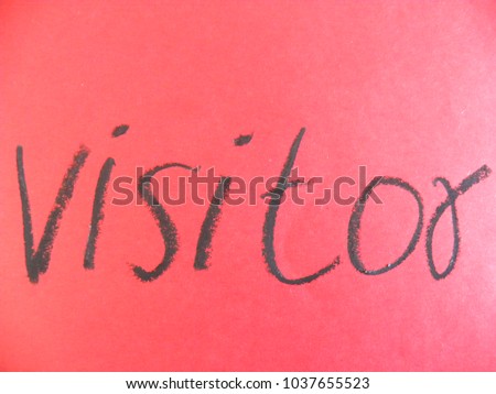 Text visitor hand written by black oil pastel on red color paper
