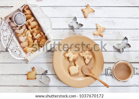 Close-up of a cute butterfly and rabbit  cookies on a plate  on a vintage white background. Spring and Easter concept, top view, space for text