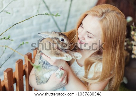 Young tender blondie girl with rabbit bunny indoors on Easter day