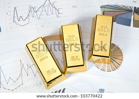 Photo of gold bars on graphs and statistics, studio shots, closeup