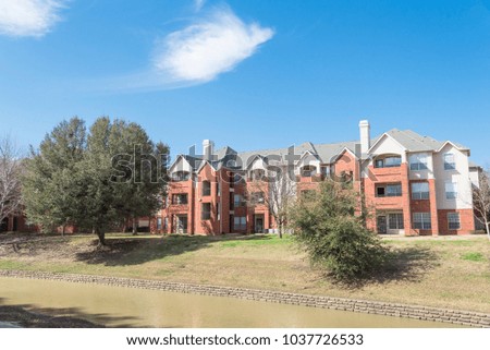 Typical riverside apartment building complex at springtime in Irving, Texas, USA. Cloud blue sky and blossom tree.