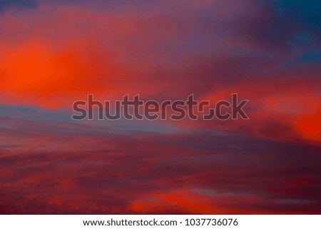 Dramatic sunset sky with clouds painted in vivid red and orange tones