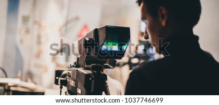 Behind the scene. Cameraman shooting the film scene with his camera in film studio