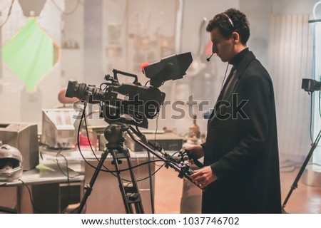 Behind the scene. Cameraman shooting the film scene with his camera in film studio