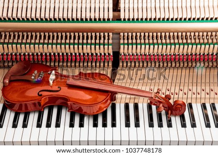 violin on black and white piano keys with inside the piano background