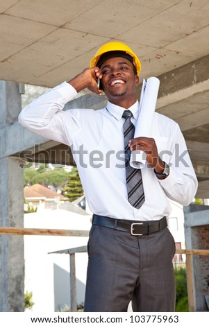 Corporate African man in construction helmet on his cell phone