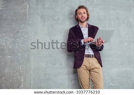 Portrait of beaming unshaven businessman typing in laptop. Employer having job with gadget concept. Copy space