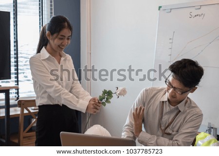 A business man refusing a white rose from coworker; heartbroken concept