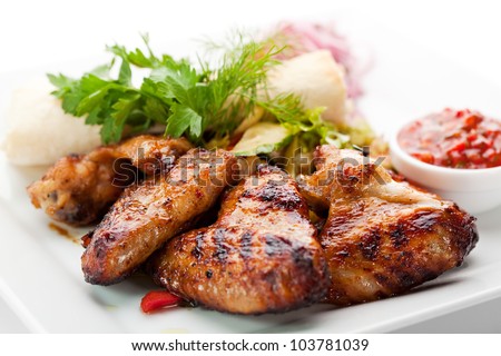 Hot Meat Dishes - Grilled Chicken Wings with Red Spicy Sauce Royalty-Free Stock Photo #103781039