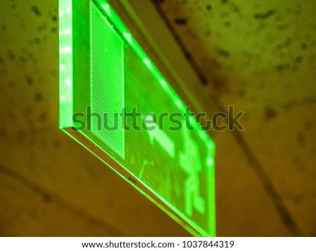 Indoor view green emergency fire exit sign on ceiling