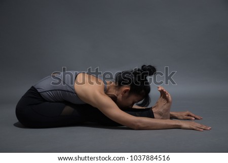 Young woman posing doing yoga exercise in studio.