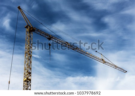 a construction crane outdoors under cloudy sky