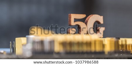 Wooden '5G' symbol on computer motherboard. Conceptual 5th generation wireless system image.