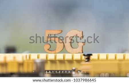 Wooden '5G' symbol on computer motherboard. Conceptual 5th generation wireless system image.