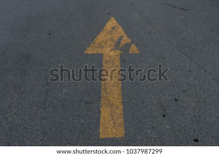 perspective yellow arrow on asphalt road