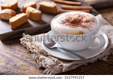 Cup of cappuccino coffee on wooden table Royalty-Free Stock Photo #1037995357
