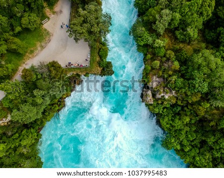Stunning aerial wide angle drone view of Huka Falls waterfall in Wairakei near Lake Taupo in New Zealand. The waterfall is part of the Waikato River and is a major tourist attraction. Royalty-Free Stock Photo #1037995483