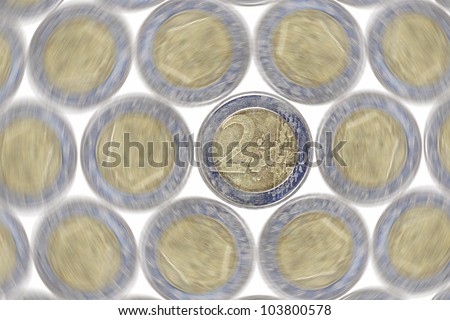 Euro currency coin on a tray of spinning coin against white.