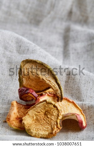 Top view close-up picture of dried apples on light cotton tablecloth, selective focus.
