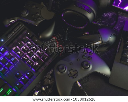 Gamer workspace concept with gaming gear, mouse, keyboard, joystick, Headset and mouse mat on table background with RGB Color. Royalty-Free Stock Photo #1038012628