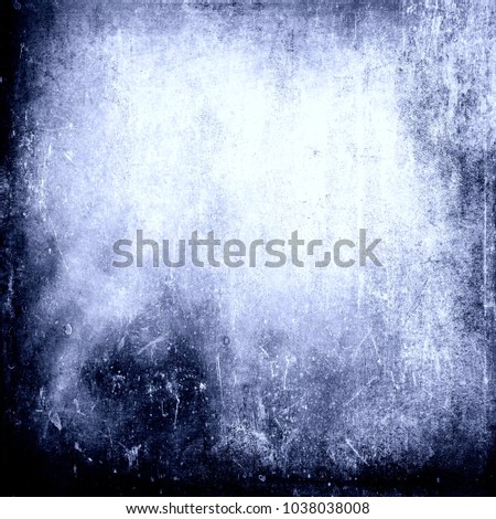Grunge blue scratched background with faded central area for text or picture