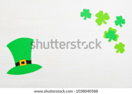 St. Patrick's Day theme colorful horizontal banner. Leprechaun hat and green shamrock leaves on white wooden background with copy space. Felt craft elements for greeting card.