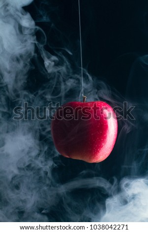 Red apple on a black background in smoke