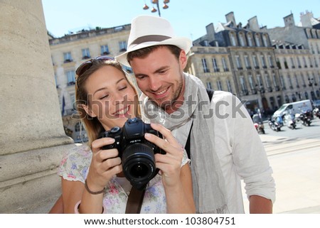 Couple enjoying taking pictures while visiting city