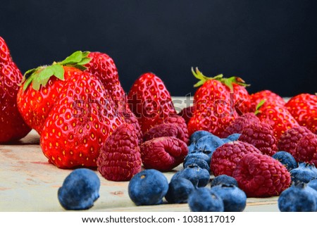 Healthy mixed fruit and ingredients with strawberry, raspberry, blueberry. Berries on rustic white wooden background. Free space for text. Copy space for banner.