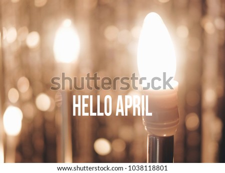 Hello April text on glitter vintage lights background. defocused. Image has grain or blurry or noise and soft when view at full resolution.