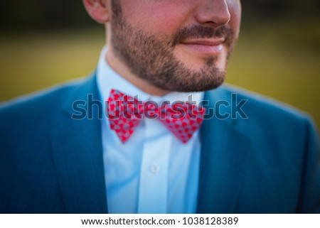 Preparing an elegant man with a red bowtie  and a blue suit Royalty-Free Stock Photo #1038128389
